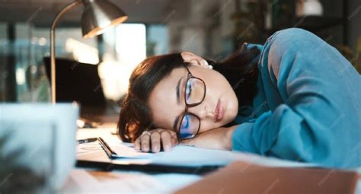 A woman sleeping at work during a meeting.